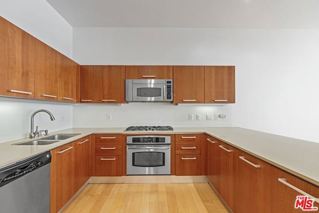 kitchen featuring light wood-type flooring, sink, and appliances with stainless steel finishes