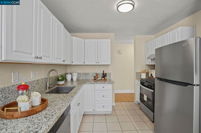 kitchen with light tile patterned floors, white cabinetry, sink, and appliances with stainless steel finishes