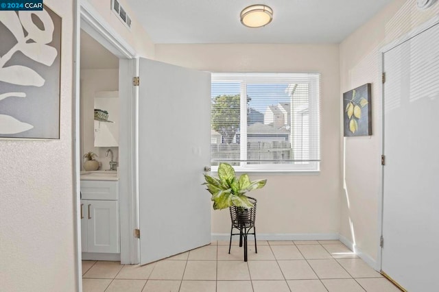 hallway with sink and light tile patterned flooring