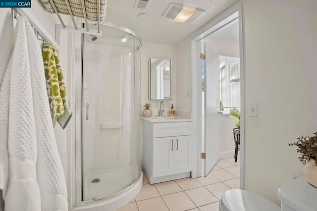 bathroom featuring tile patterned floors, a shower with door, vanity, and toilet