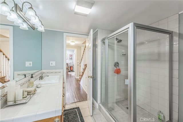 bathroom with hardwood / wood-style floors, vanity, and a shower with shower door