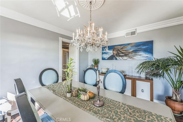 dining area featuring ornamental molding and an inviting chandelier