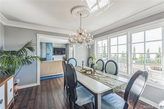 dining room with dark hardwood / wood-style flooring, ornamental molding, and an inviting chandelier