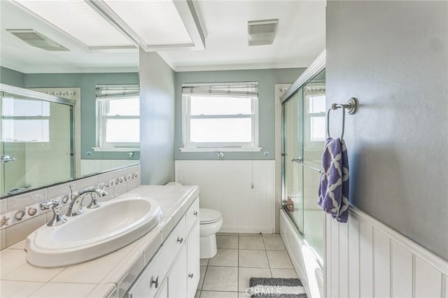 full bathroom with backsplash, bath / shower combo with glass door, vanity, tile patterned flooring, and toilet