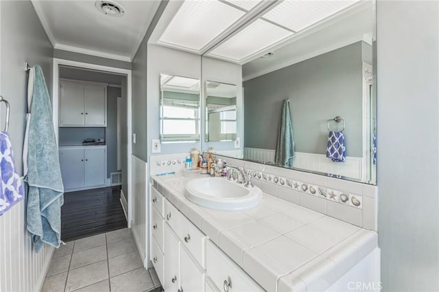 bathroom featuring tile patterned flooring, vanity, and crown molding