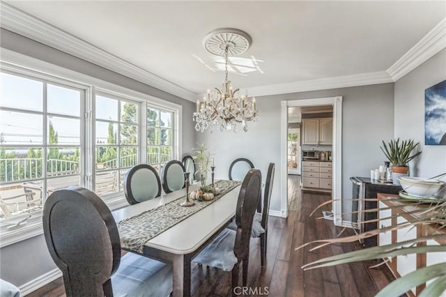 dining space featuring dark hardwood / wood-style floors, crown molding, and a chandelier