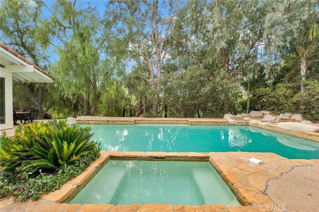 view of pool featuring an in ground hot tub