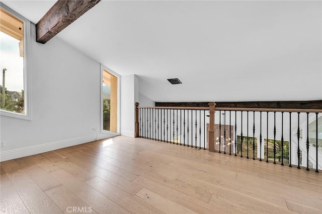 bonus room featuring lofted ceiling with beams, light hardwood / wood-style flooring, and a healthy amount of sunlight