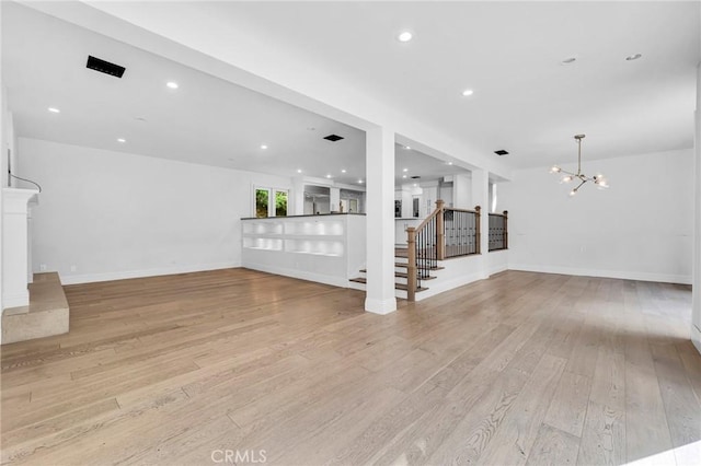 unfurnished living room featuring light hardwood / wood-style floors and a notable chandelier