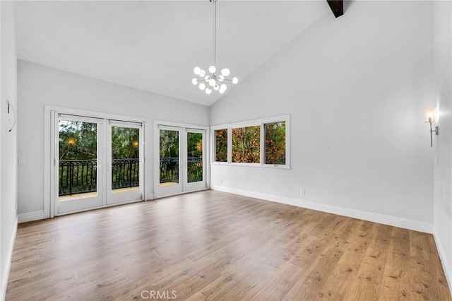 unfurnished room with a healthy amount of sunlight, high vaulted ceiling, and light hardwood / wood-style flooring