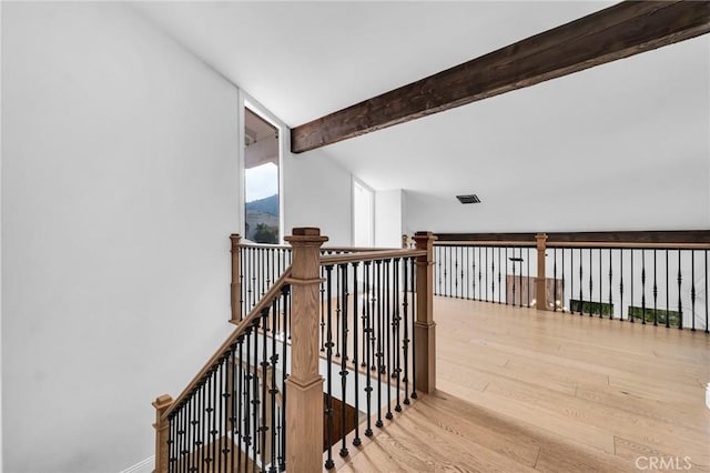 stairs with hardwood / wood-style floors and lofted ceiling with beams