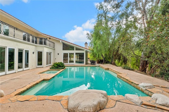 view of swimming pool with an in ground hot tub