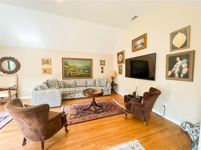 living room with wood-type flooring and lofted ceiling