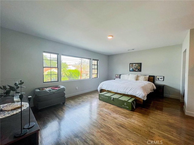 bedroom with dark hardwood / wood-style flooring