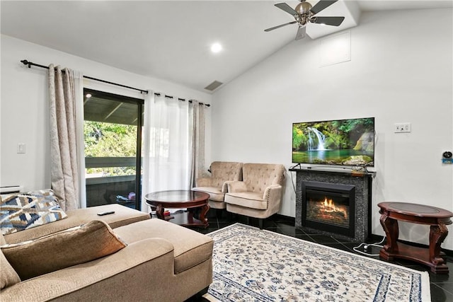 living room featuring ceiling fan, dark tile patterned floors, and vaulted ceiling