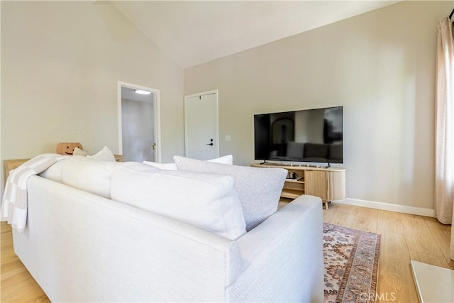 living room featuring high vaulted ceiling and light wood-type flooring