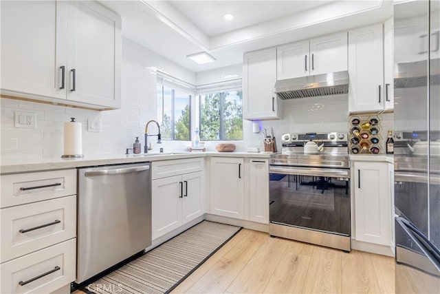 kitchen featuring decorative backsplash, light wood-type flooring, white cabinetry, and stainless steel appliances