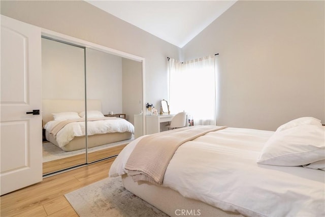 bedroom featuring a closet, hardwood / wood-style floors, and lofted ceiling