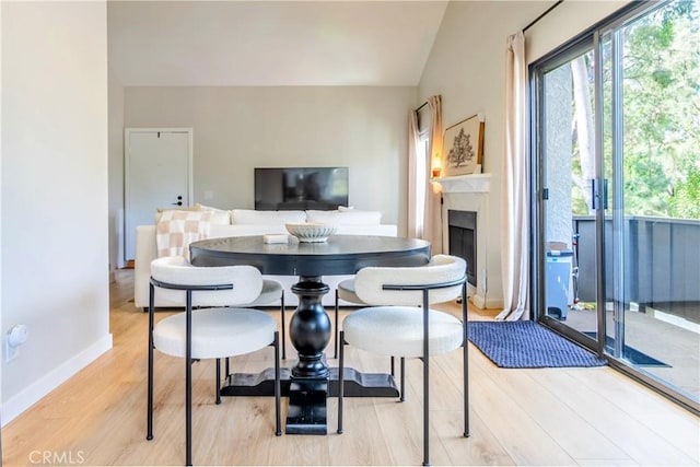 dining area featuring light hardwood / wood-style flooring and lofted ceiling