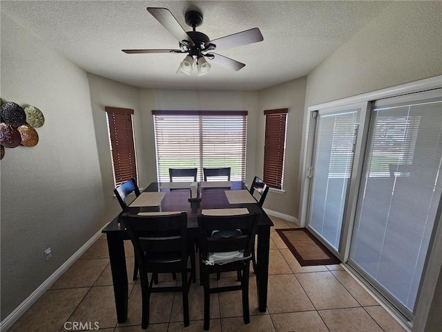 dining room featuring light tile patterned floors, a textured ceiling, a ceiling fan, and baseboards