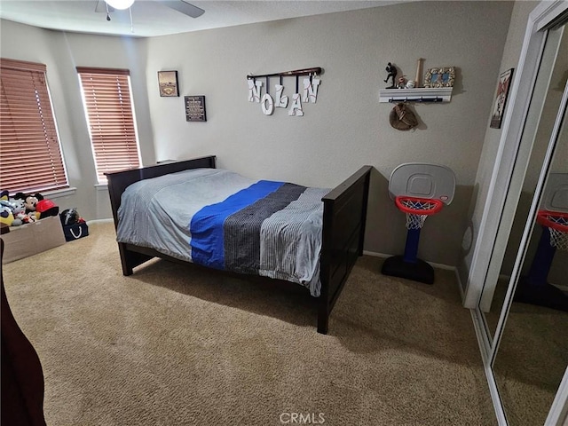 carpeted bedroom with ceiling fan and baseboards