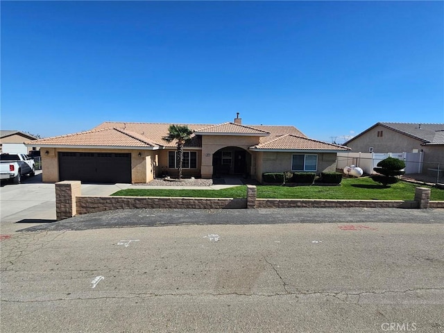 view of front of house featuring a garage, fence, concrete driveway, a tiled roof, and stucco siding