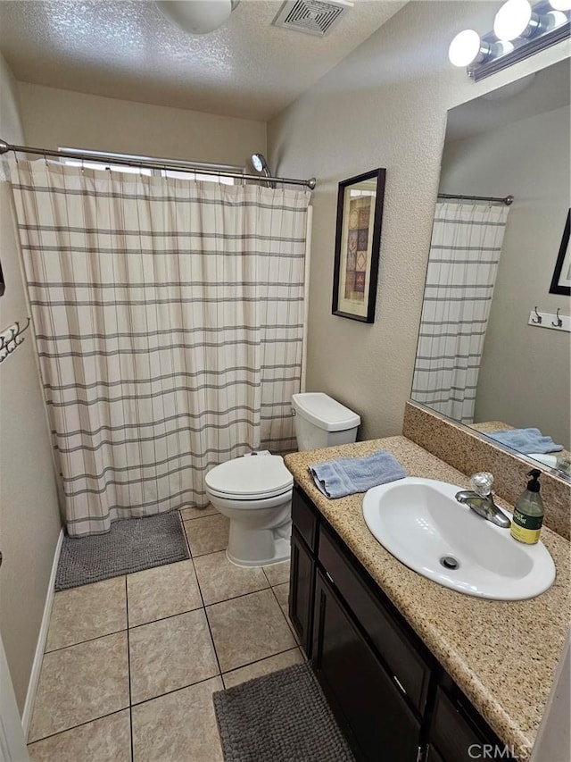 bathroom featuring visible vents, toilet, vanity, a textured ceiling, and tile patterned floors