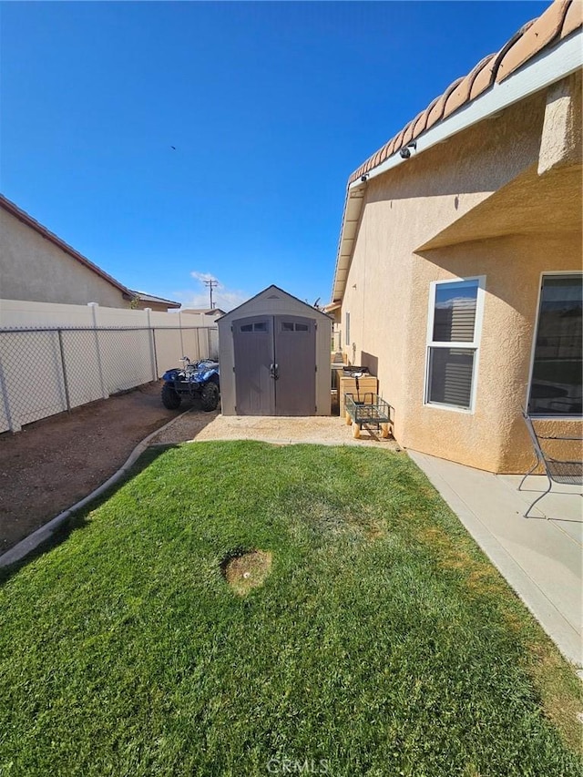 view of yard with an outbuilding, a storage unit, and a fenced backyard