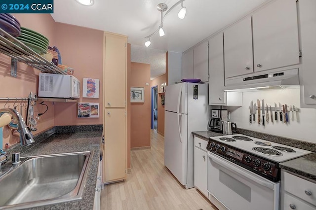 kitchen featuring white appliances, rail lighting, sink, light hardwood / wood-style flooring, and white cabinetry