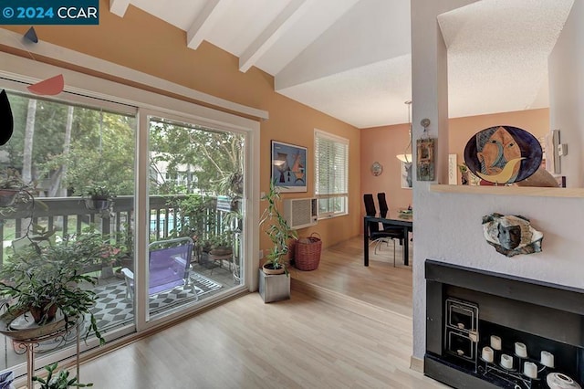 doorway to outside with plenty of natural light, lofted ceiling with beams, and wood-type flooring