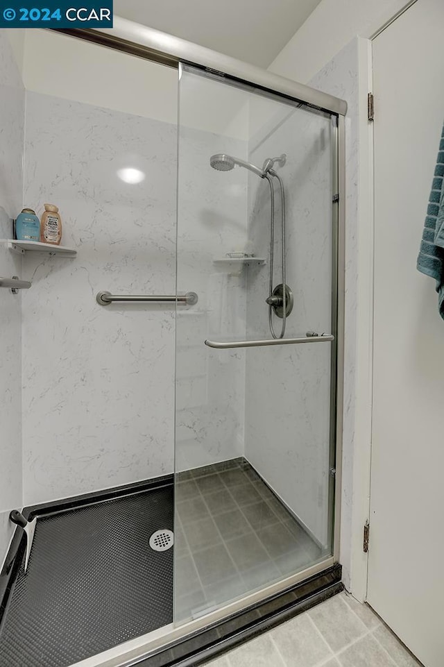 bathroom featuring tile patterned flooring and a shower with shower door