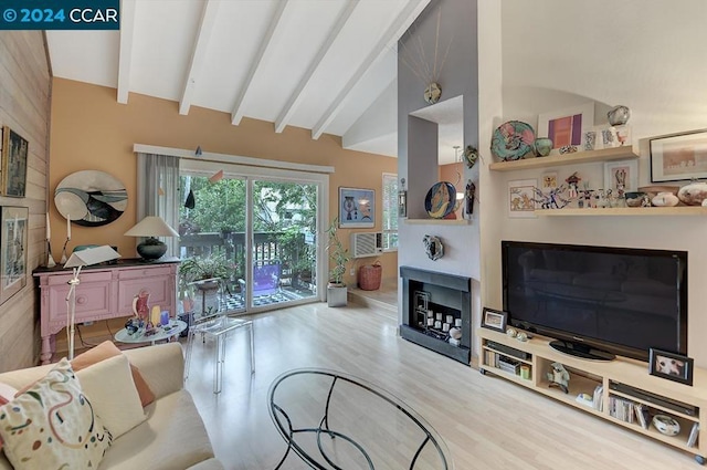 living room featuring light wood-type flooring and lofted ceiling with beams