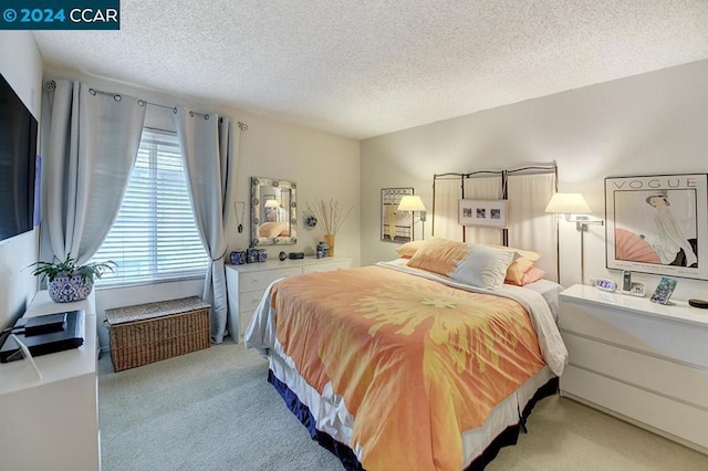 bedroom featuring a textured ceiling and light colored carpet