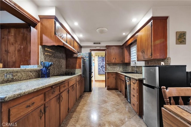 kitchen with light stone counters, sink, backsplash, and black appliances