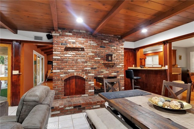 living room with a wealth of natural light, light tile patterned flooring, bar area, and beamed ceiling