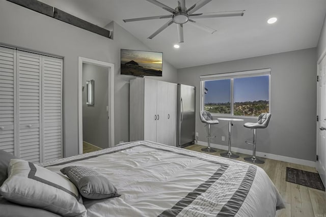 bedroom with ceiling fan, lofted ceiling, stainless steel fridge, and light wood-type flooring