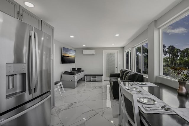 kitchen with gray cabinetry, stainless steel fridge with ice dispenser, and a wall mounted AC