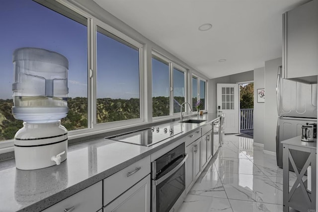 kitchen with marble finish floor, white cabinetry, stainless steel appliances, and a sink