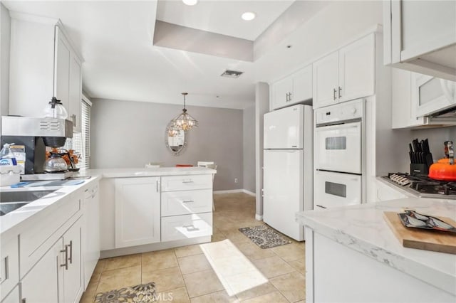 kitchen featuring white cabinets, white appliances, decorative light fixtures, and light tile patterned flooring