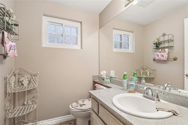 bathroom with plenty of natural light, vanity, and toilet