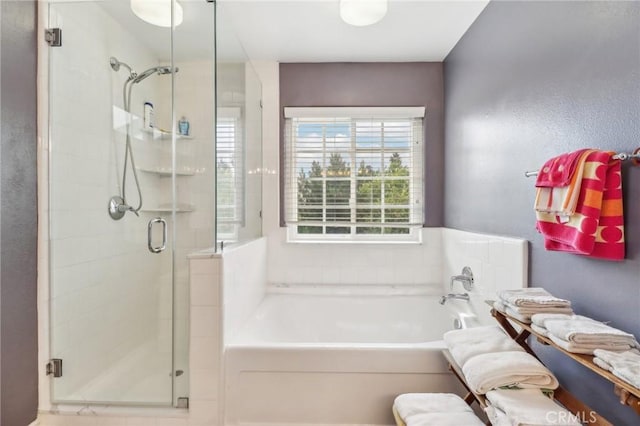 bathroom featuring shower with separate bathtub