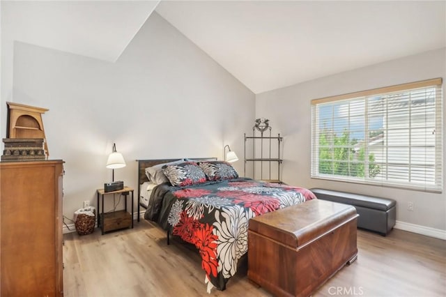 bedroom featuring light hardwood / wood-style flooring and lofted ceiling