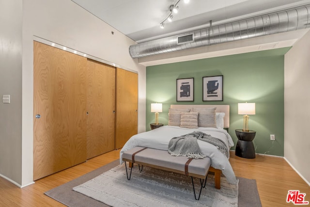 bedroom featuring hardwood / wood-style floors and a closet