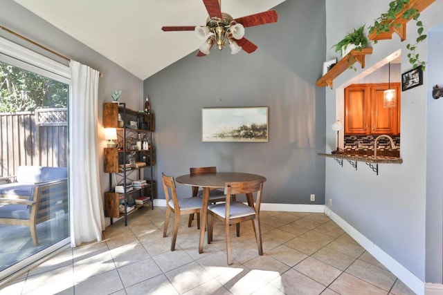 dining area with light tile patterned floors, vaulted ceiling, and ceiling fan