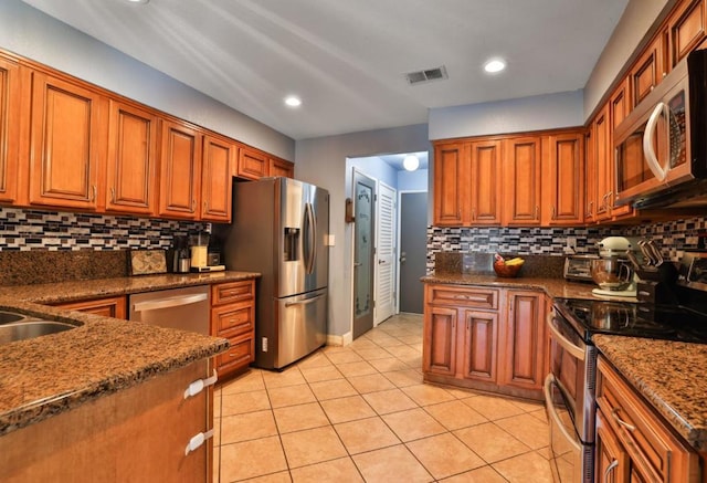 kitchen with backsplash, light tile patterned floors, stainless steel appliances, and sink