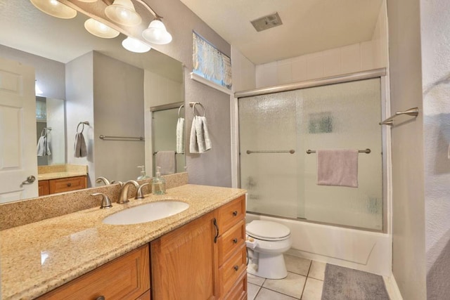 full bathroom with vanity, tile patterned floors, shower / bath combination with glass door, and toilet