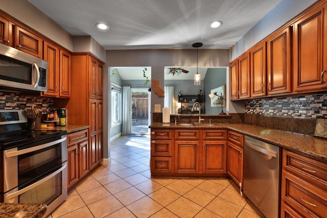 kitchen featuring sink, decorative backsplash, stainless steel appliances, and light tile patterned flooring