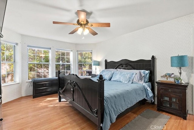 bedroom with light hardwood / wood-style flooring and ceiling fan