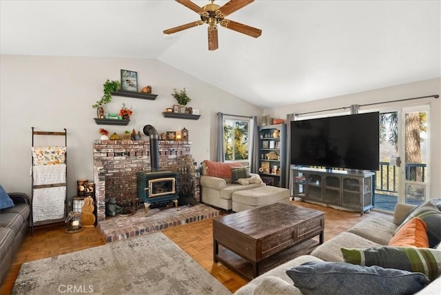 living room with ceiling fan, parquet flooring, vaulted ceiling, and a wood stove