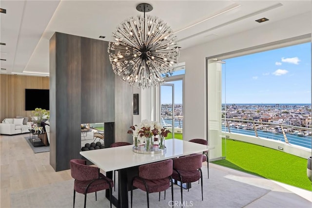 dining space featuring a chandelier, light hardwood / wood-style flooring, and wood walls